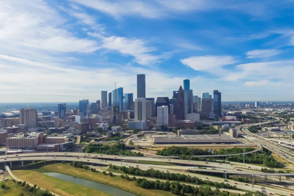 Serial view of elevated freeway interchanges with downtown Houston in background